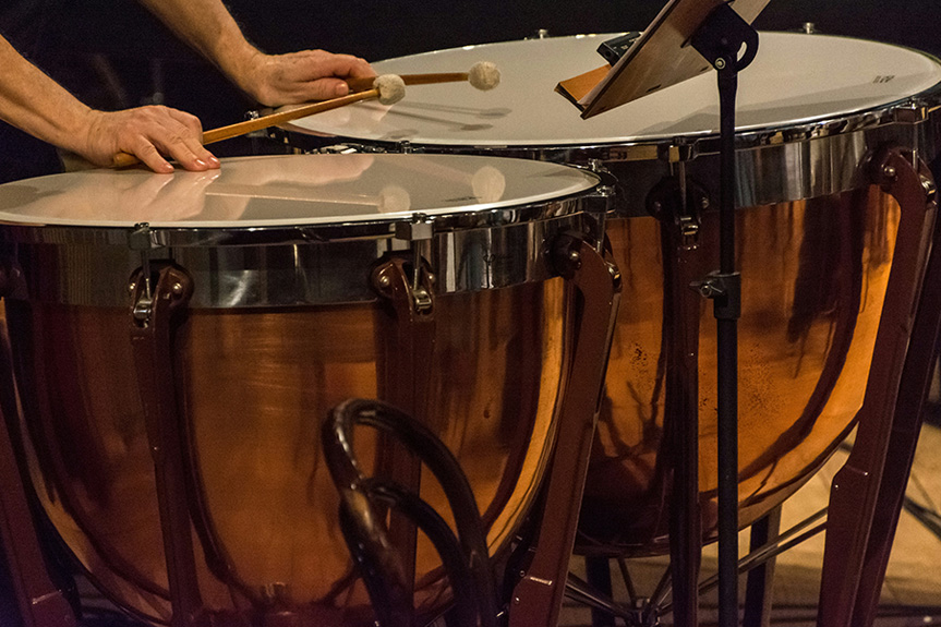 A musician playing timpani. A large copper or fiberglass drums used in orchestras